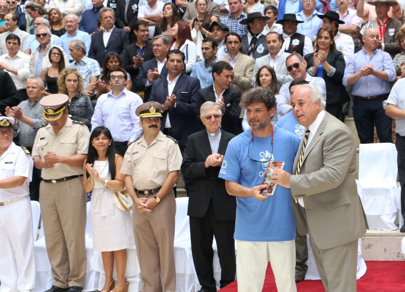 El vicegobernador Dr. Marcelo Lima en el momento de entrega de un escapulario y un ejemplar del libro "El Cruce. Tras los pasos de San Martín" a uno de los expedicionarios.