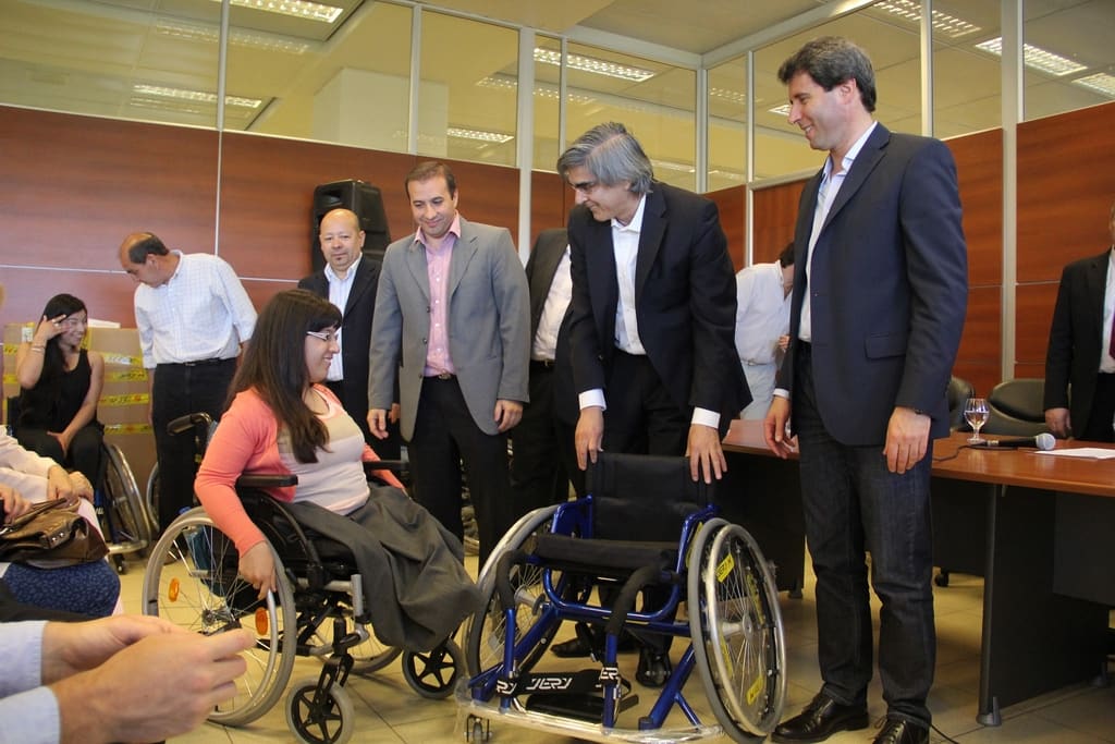 El vicegobernador Sergio Uñac y el ministro de Desarrollo Humano y Promoción Social, Daniel Molina entregando una silla de ruedas deportiva a Carolina Pantano. 