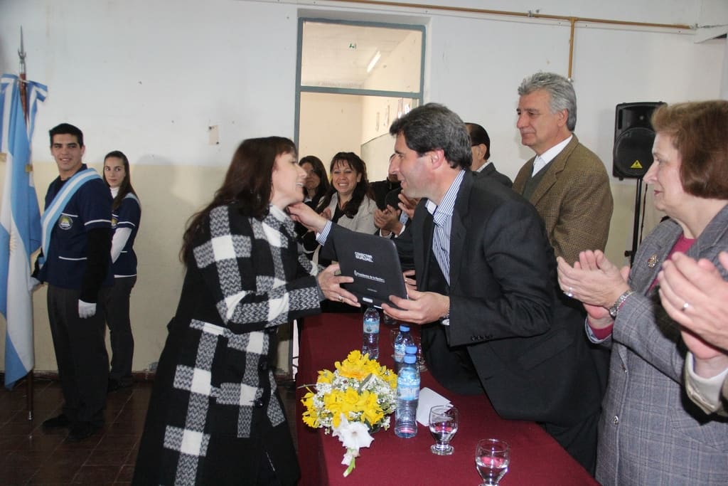 El Dr. Sergio Uñac entrega netbook a una docente de la institución