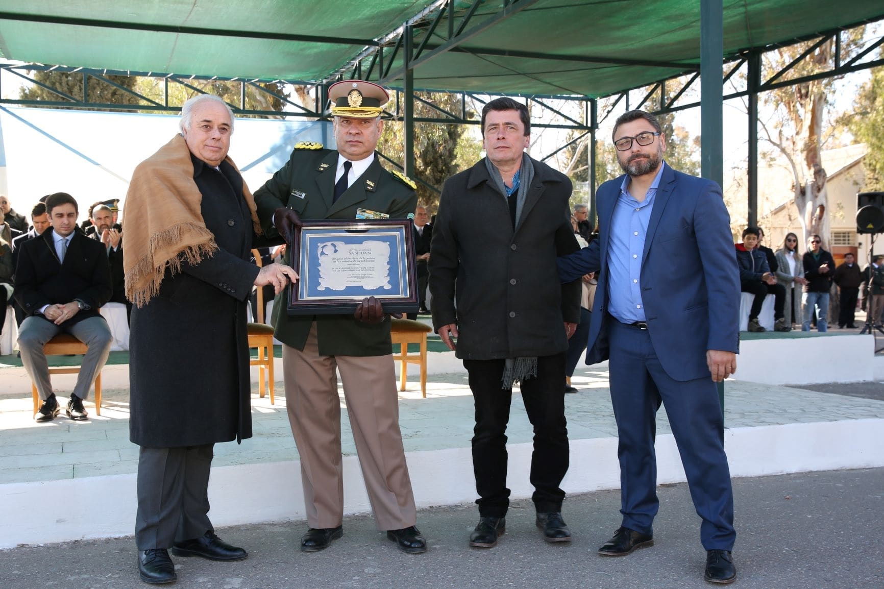 El vicegobernador en ejercicio del Poder Ejecutivo, Marcelo Lima junto a los diputados Héctor Pérez y Andrés Chanampa entrega una placa recordatoria al jefe de la X Agrupación de Gendarmería, Miguel Hugo Castagna.